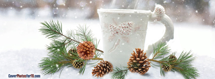 a picture of a white coffee cup with pine cones on the handle and as a design on the cup. It's surrounded by snow and snowflakes and pine boughs and cones.